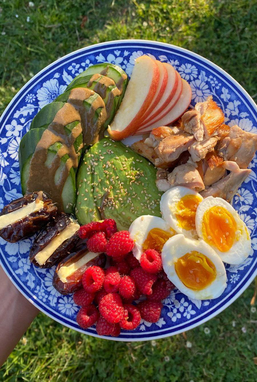 Kleurrijk bord met groente, fruit, ei en kip